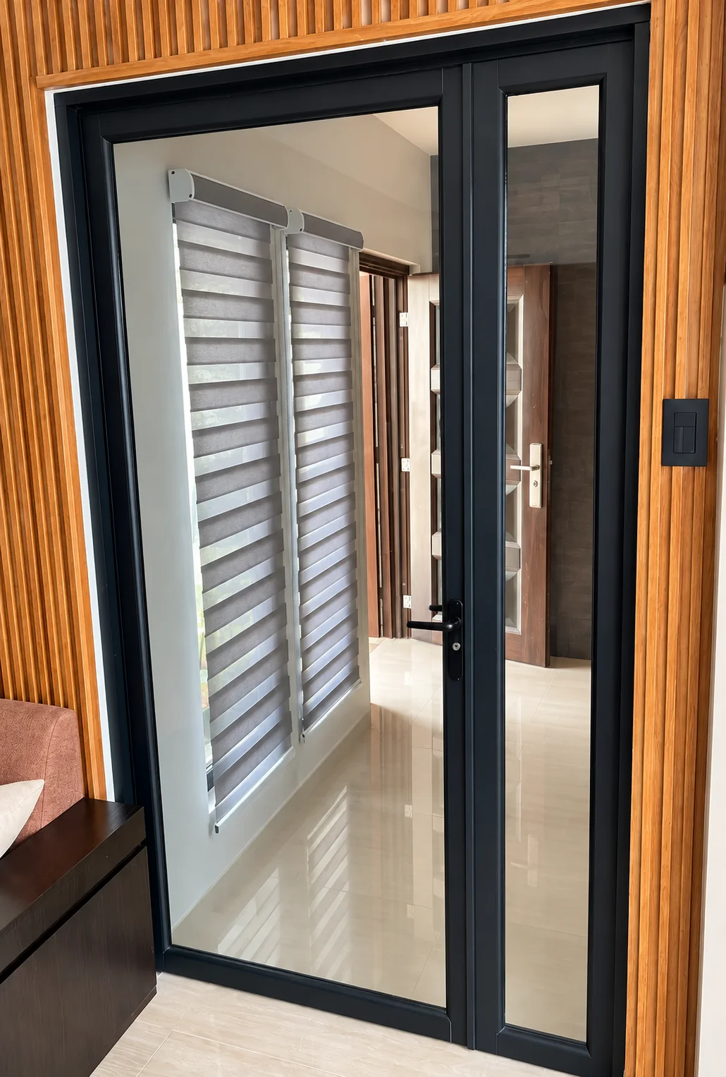 Puerta abatible de aluminio negro y vidrio instalada en interior